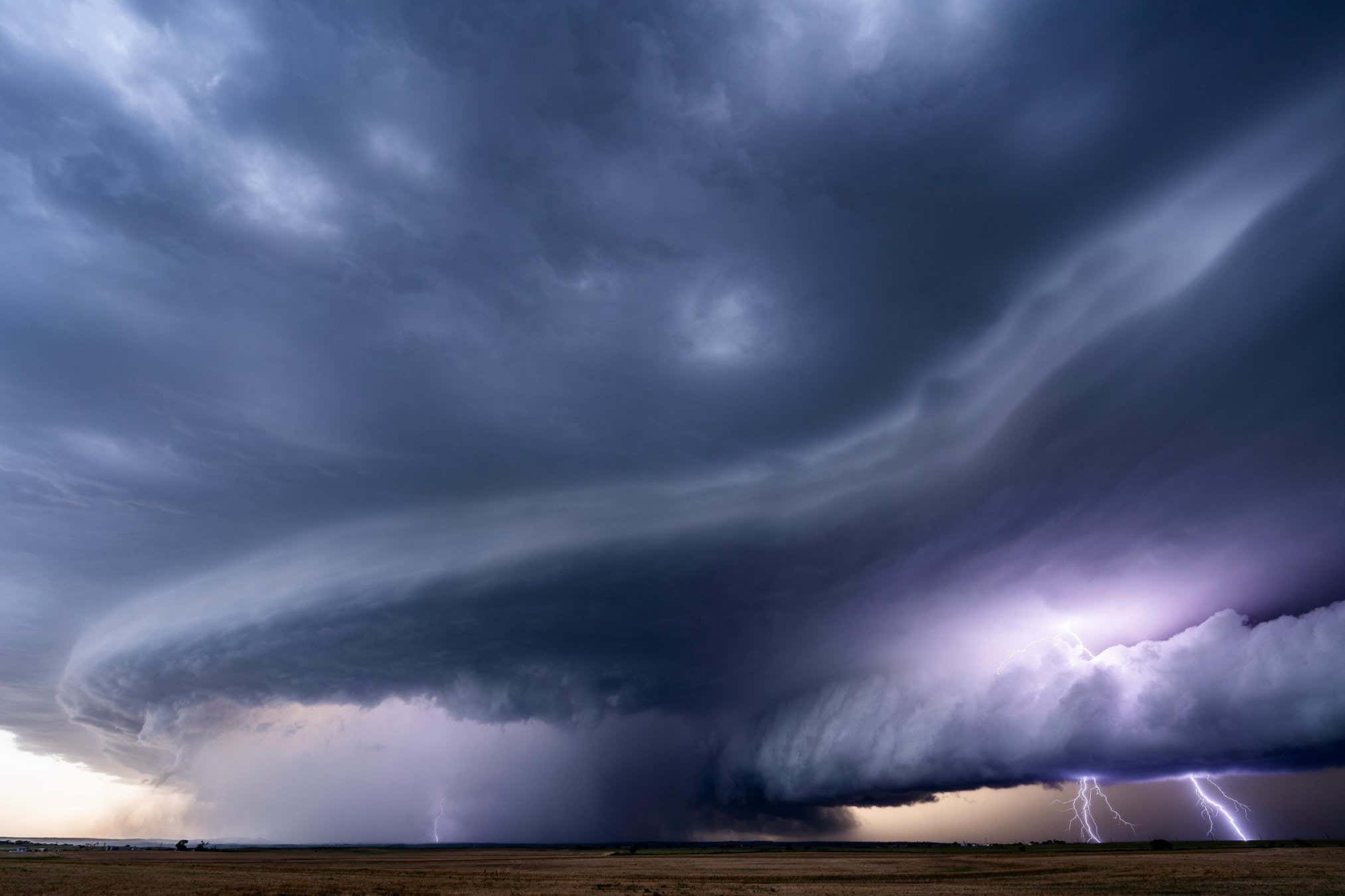 This is a supercell photographed near Arnett, Oklahoma on June 17th. At the moment of the picture, a tornado is ongoing in the center of the image buried in rain, and hail bigger than 55mm (2.17???) is falling and being collected by the hail hunting vehicle. The lightning was prolific because the storm was well over 65,000 feet tall during its peak strength. The lightning was so constant that in 1/8th of a second (the exposure time of this picture), I was able to capture 3 strikes. Most of the lightning was positive, which is stronger than the typical lightning strike which are negative. This can be an indicator of an abundance of hail within the storm, as hail can increase the amount of built up electrical charge within the updraft. Positive strikes typically originate from the top of the storm (anvil) and are characterized by one singular channel without much branching (leftmost strike). Typically striking within the inflow of the storm, they also only strike once instead of strobing with multiple strokes/pulses like negatively charged lightning does. Hope this is enough information about the storm! I can always share more if needed.