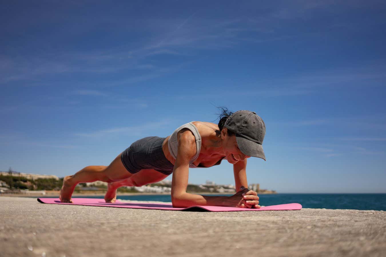 Brunette Woman Performing Isometric Exercises on Pink Exercise M; Shutterstock ID 2490925757; purchase_order: -; job: -; client: -; other: -