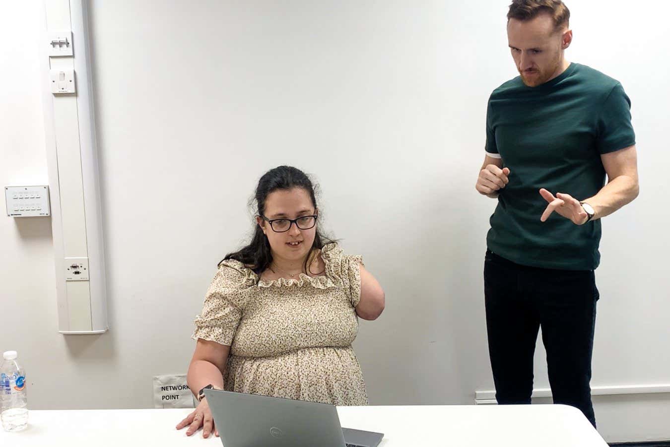Trial participant Emily Wheldon with one of the researchers as she practiced attempting to move the lost fingers from her amputated arm before going into an MRI scanner