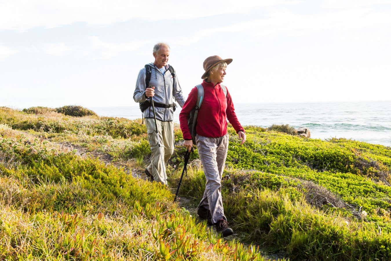 Senior couple (aged 65-69) hiking together on a coastal path