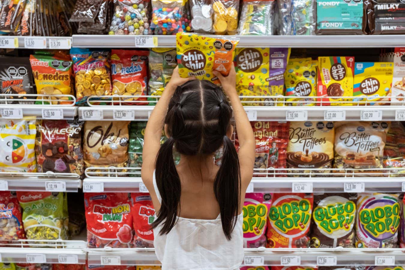 A child in Peru takes candy from a shelf