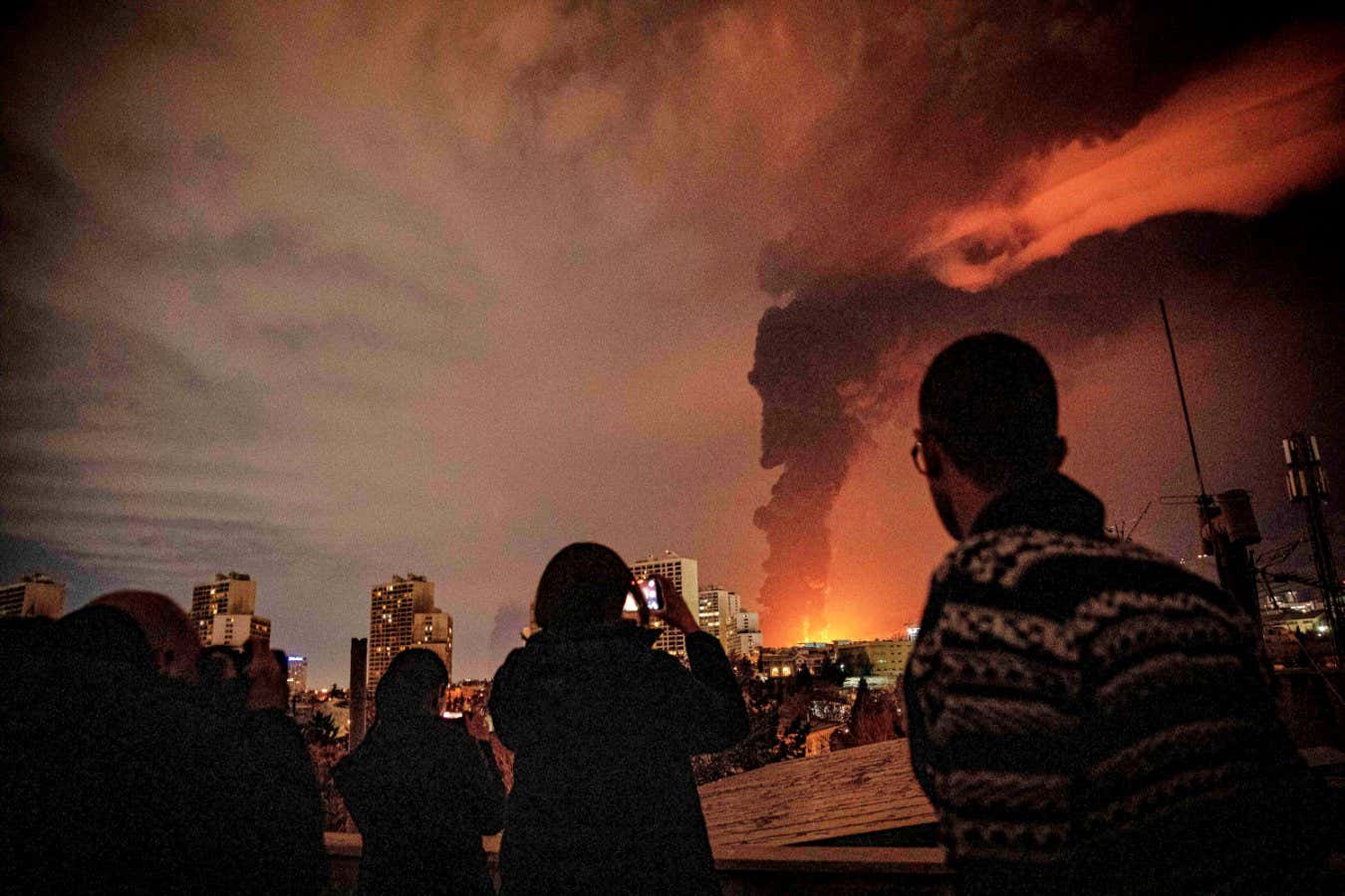 flames and smoke rise from an oil storage facility struck in Iran